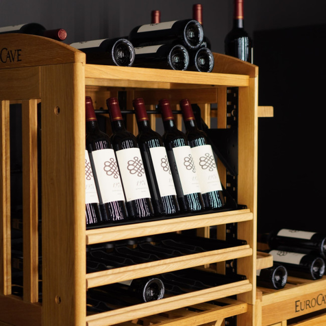 Articulated display on a sliding shelf to showcase wine bottles and make labels easier to see and read.