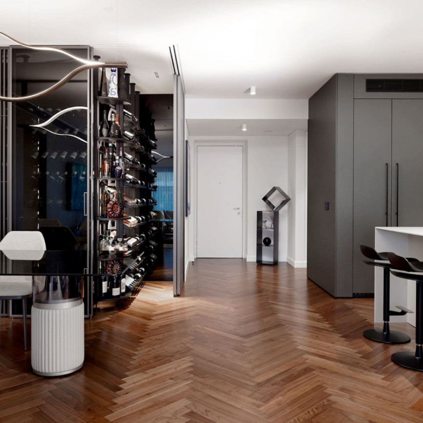 Glazed and air-conditioned wine cellar showcase in a dining room with open kitchen in a luxury flat. Modulo-X EuroCave metal wine storage unit