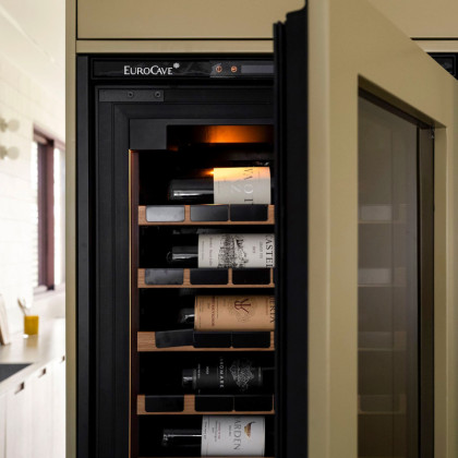 Modern home design highlighting a built-in EuroCave wine fridge within custom green millwork.