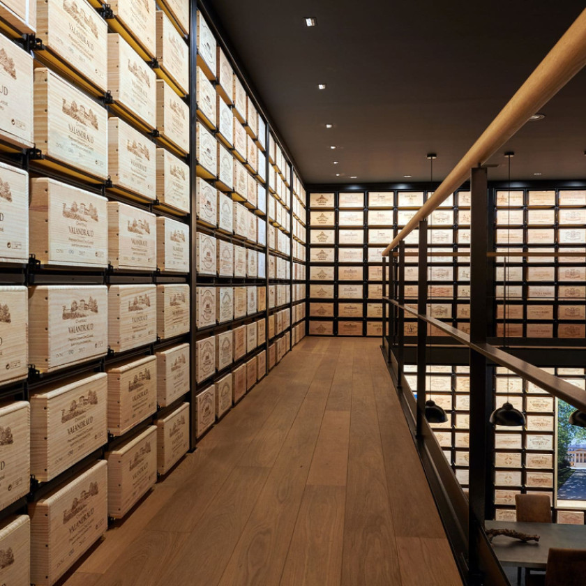 Professional wine storage at Château Teyssier, Saint-Émilion, with sliding wooden case racks.